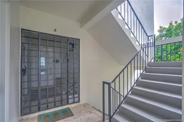 a view of staircase with railing and white walls