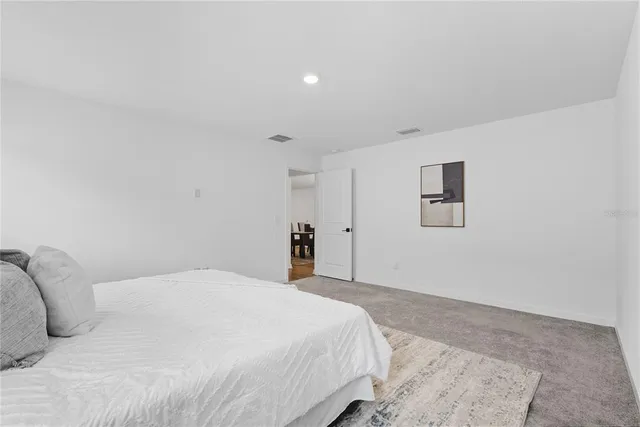 a bedroom with a bed and a painting on the wall