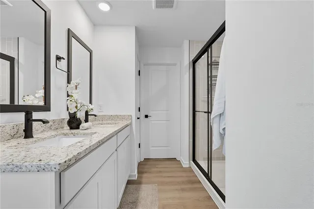 a bathroom with a granite countertop sink and a mirror