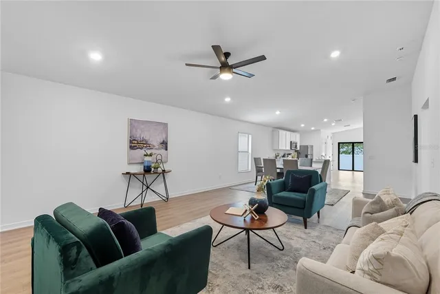 a living room with furniture and a ceiling fan