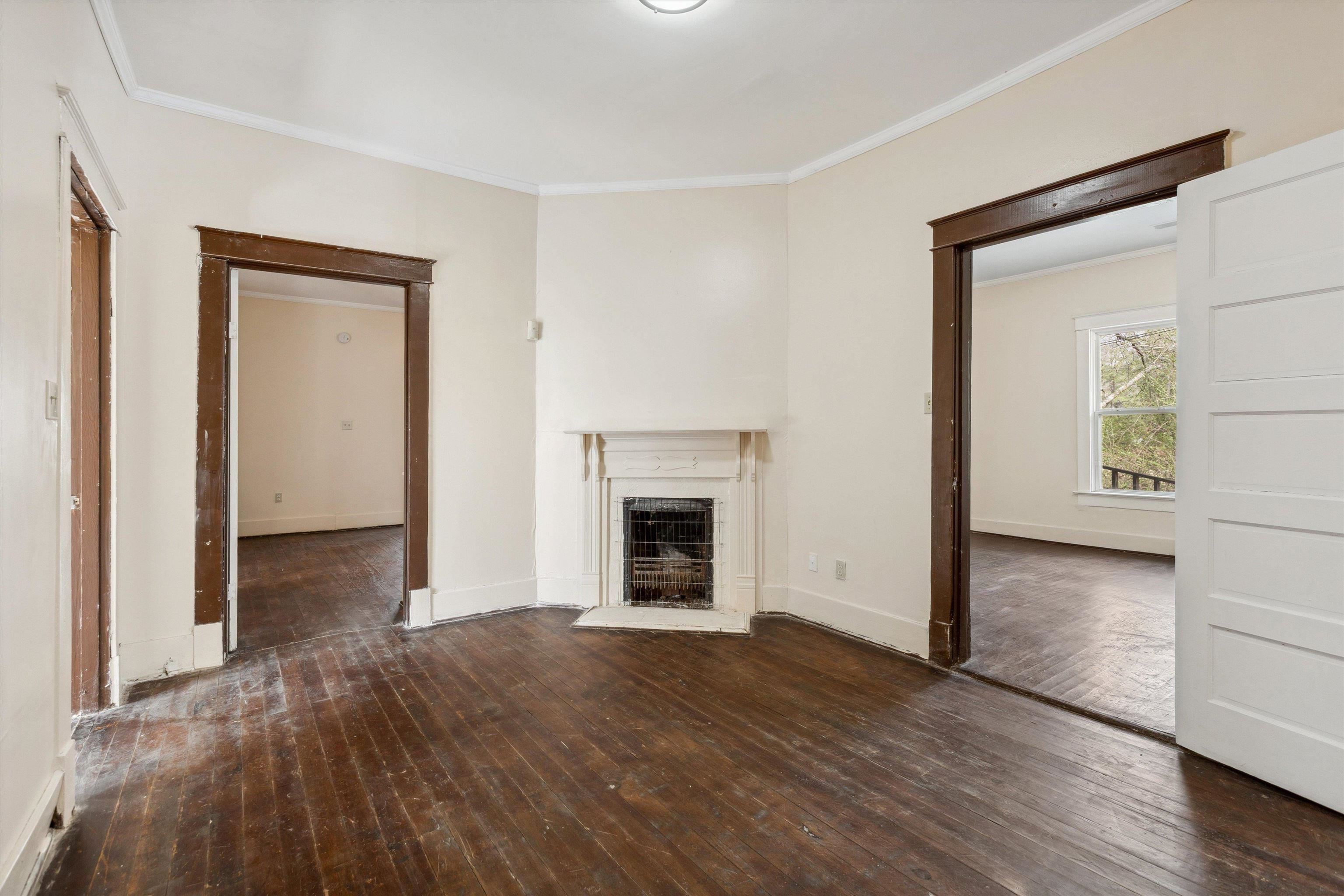8457 East Kerrville Rosemark Road Millington, TN 38053 - Photo 5 of 32 Unfurnished living room featuring dark wood-style flooring, crown molding, and a fireplace
