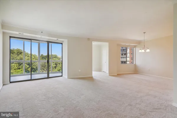 a view of an empty room with windows and view of balcony