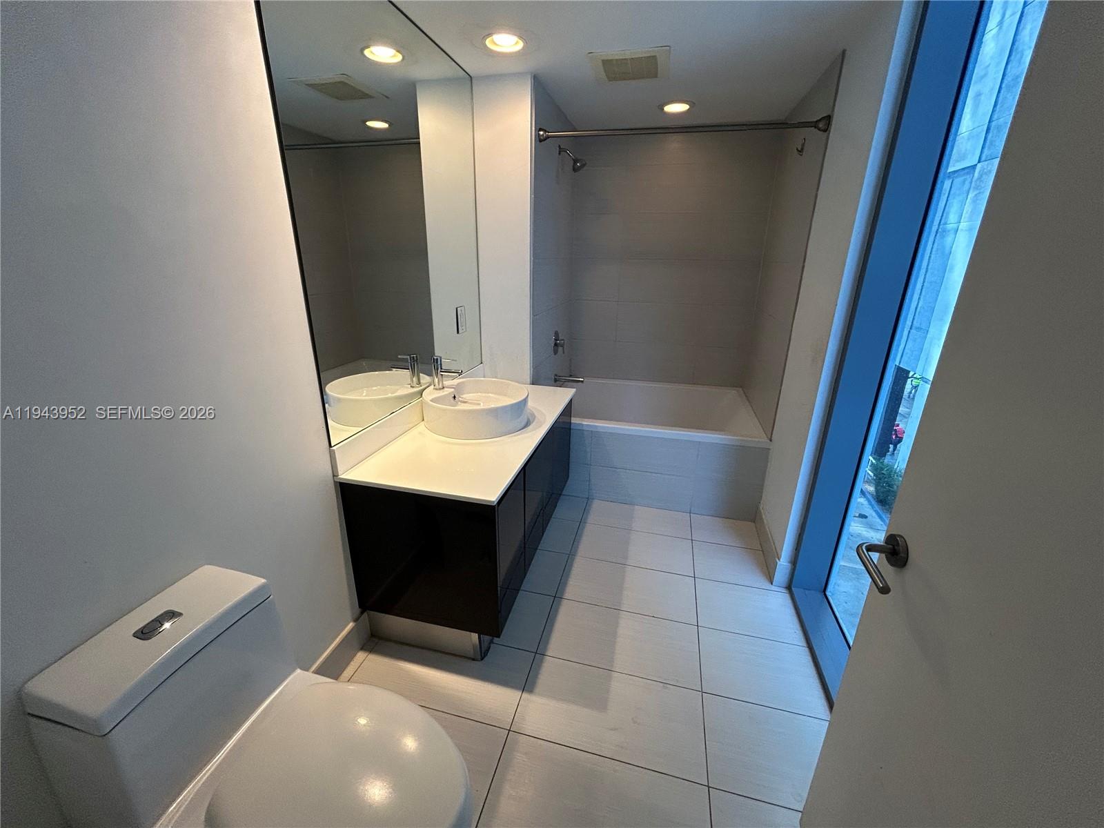 31 Southeast 6th Street, Unit 407 Miami, FL 33131 - Photo 13 of 22 a bathroom with a sink a toilet and bathtub