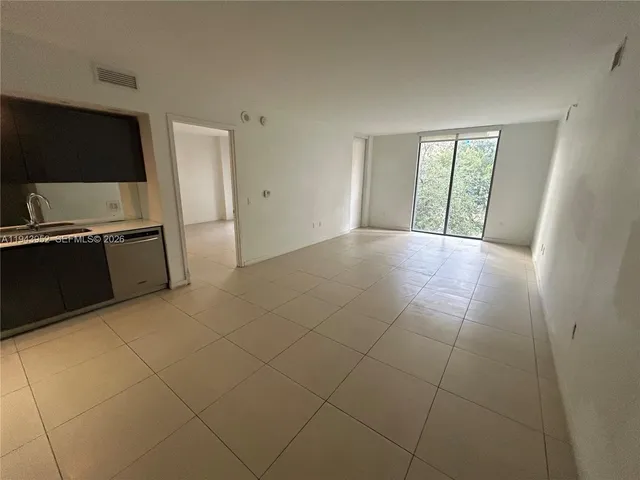 a view of an empty room with a kitchen