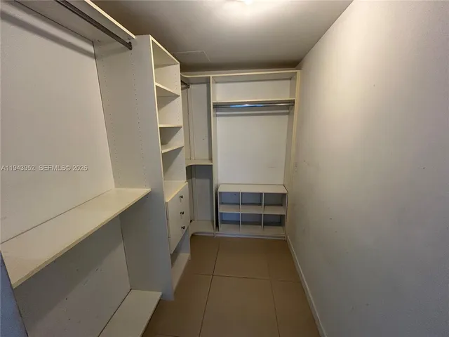 a view of walk in closet with empty racks