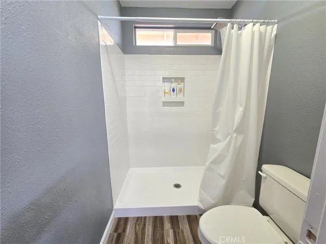a bathroom with a toilet and a shower