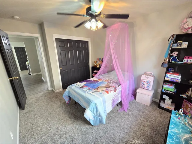 a bedroom with a bed and a flat tv screen on dresser
