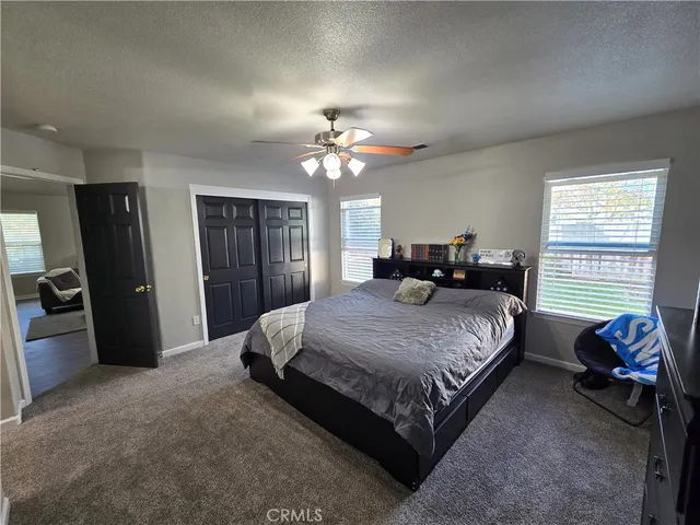 a spacious bedroom with a bed and ceiling fan