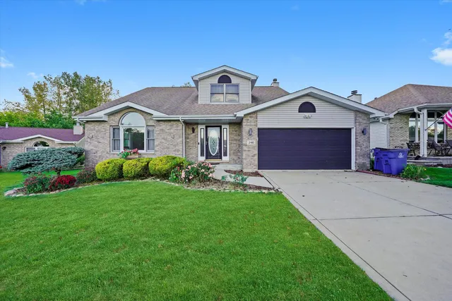 a front view of a house with a yard and garage