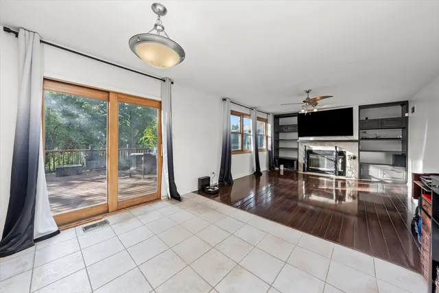 a living room with furniture a flat screen tv and a floor to ceiling window