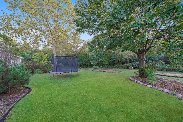 a backyard of a house with trees and wooden fence