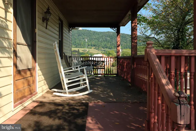a view of a deck with a floor to ceiling window and wooden fence