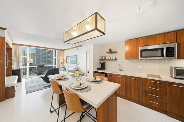 a dining room with wooden floor a glass table and chairs