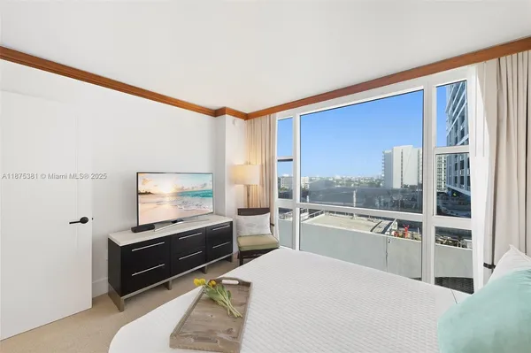 a living room with a flat screen tv and a floor to ceiling window