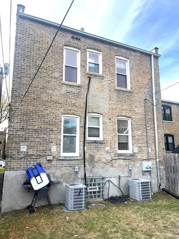 a brick house with lots of furniture and a potted plant