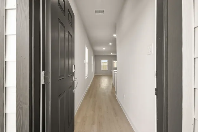 a view of a hallway with wooden floor