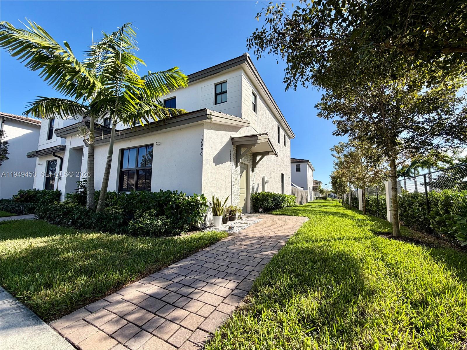 12990 Southwest 232nd Lane Homestead, FL 33032 - Photo 2 of 20 a front view of a house with a yard and potted plants