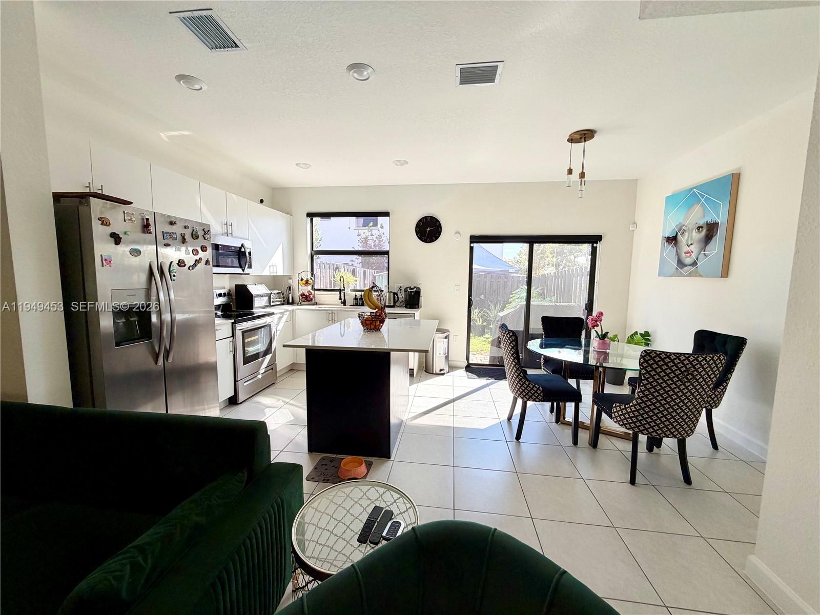 12990 Southwest 232nd Lane Homestead, FL 33032 - Photo 7 of 20 a living room with lots of furniture and a refrigerator