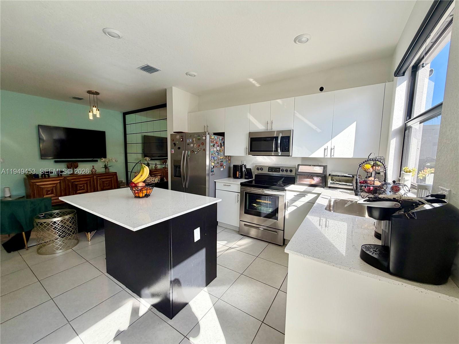 12990 Southwest 232nd Lane Homestead, FL 33032 - Photo 8 of 20 a kitchen with a stove a sink dishwasher a refrigerator and a oven with wooden floor