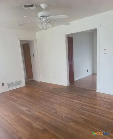 a view of empty room with wooden floor