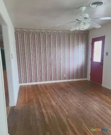 wooden floor in an empty room with a window