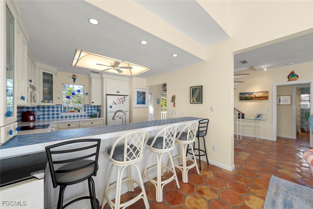 1401 Sand Castle Road Sanibel, FL 33957 - Photo 16 of 50 a kitchen with granite countertop a table and chairs