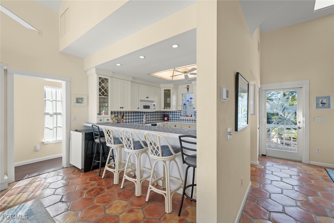 1401 Sand Castle Road Sanibel, FL 33957 - Photo 20 of 50 a view of kitchen with stainless steel appliances kitchen island granite countertop dining table chair and a refrigerator