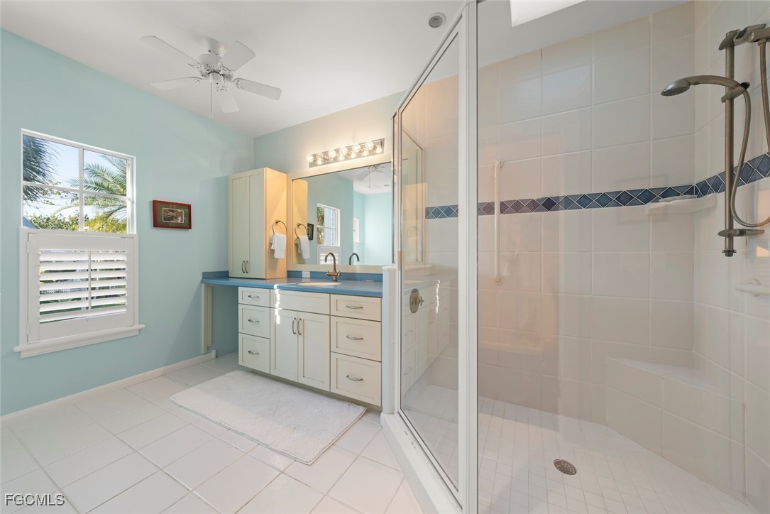 1401 Sand Castle Road Sanibel, FL 33957 - Photo 30 of 50 a spacious bathroom with a granite countertop sink a mirror and a shower