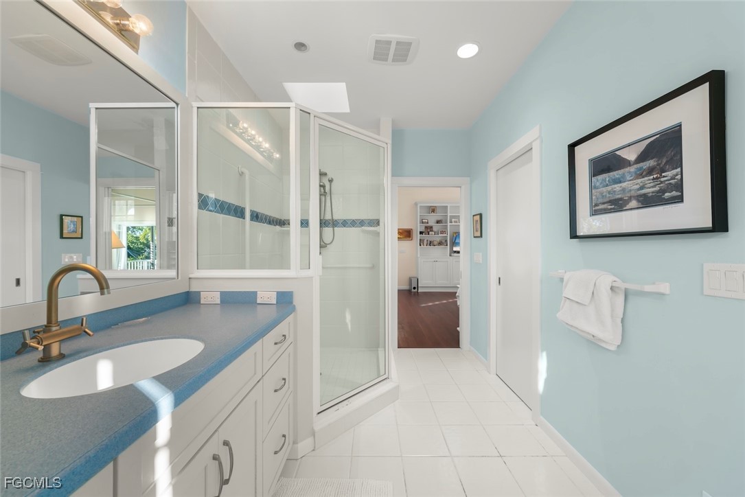1401 Sand Castle Road Sanibel, FL 33957 - Photo 31 of 50 a bathroom with a granite countertop sink a mirror and shower
