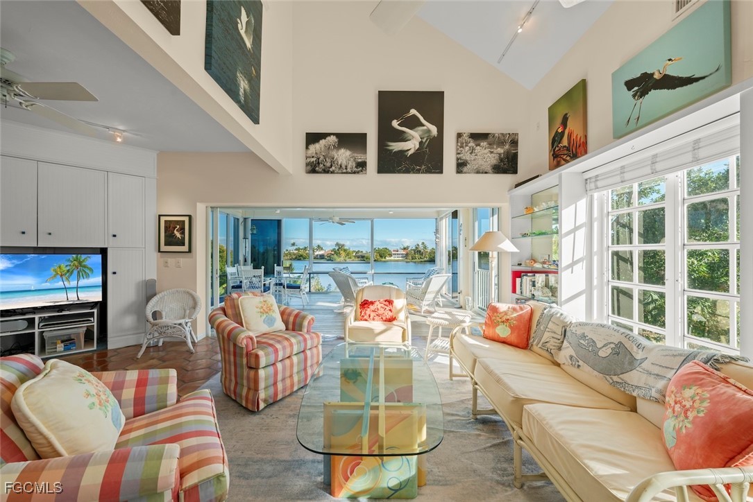 1401 Sand Castle Road Sanibel, FL 33957 - Photo 4 of 50 a living room with furniture a flat screen tv and a floor to ceiling window