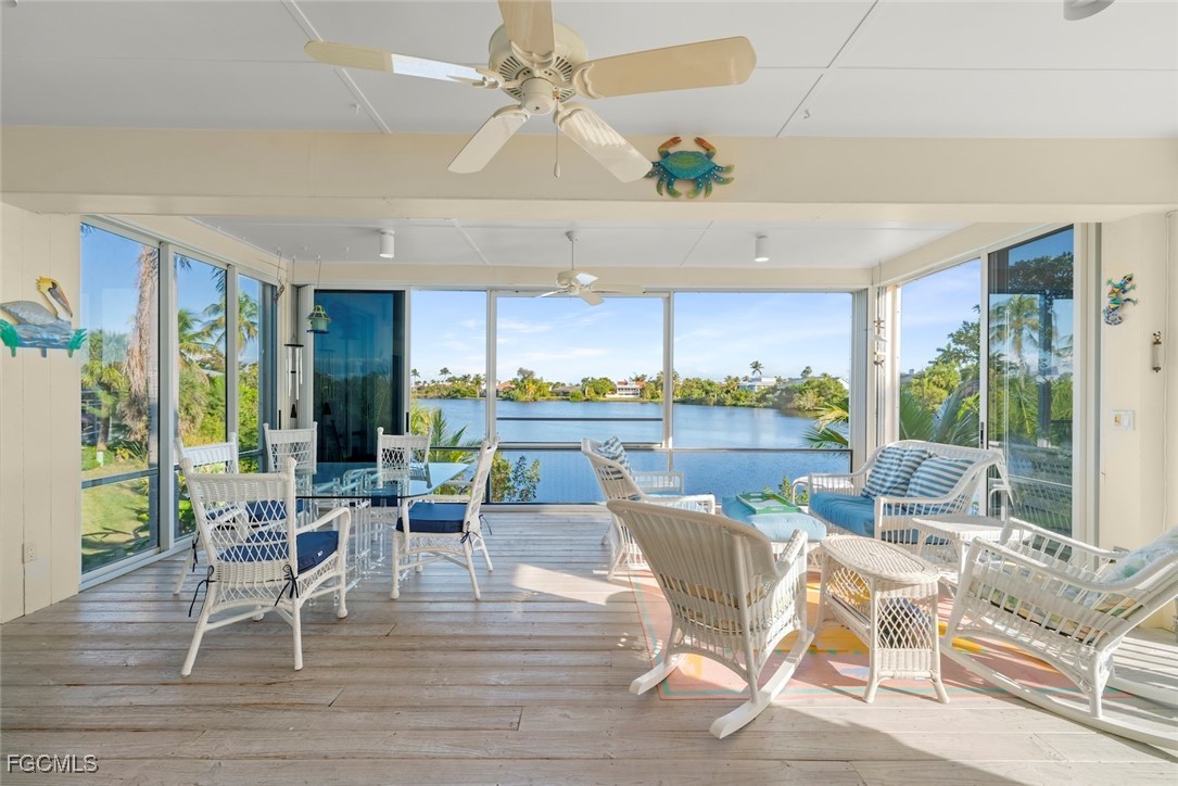 1401 Sand Castle Road Sanibel, FL 33957 - Photo 6 of 50 a dining room with furniture a floor to ceiling window and wooden floor