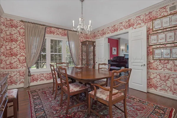 a view of a dining room with furniture a rug and wooden floor