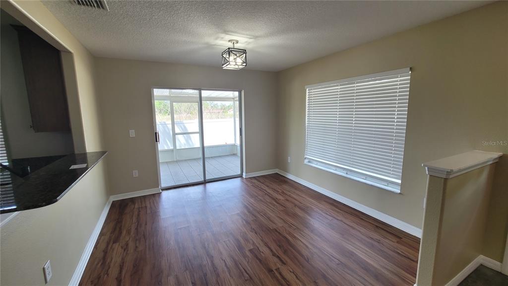 12905 Trade Port Place Riverview, FL 33579 - Photo 3 of 14 a view of an empty room with wooden floor and a window