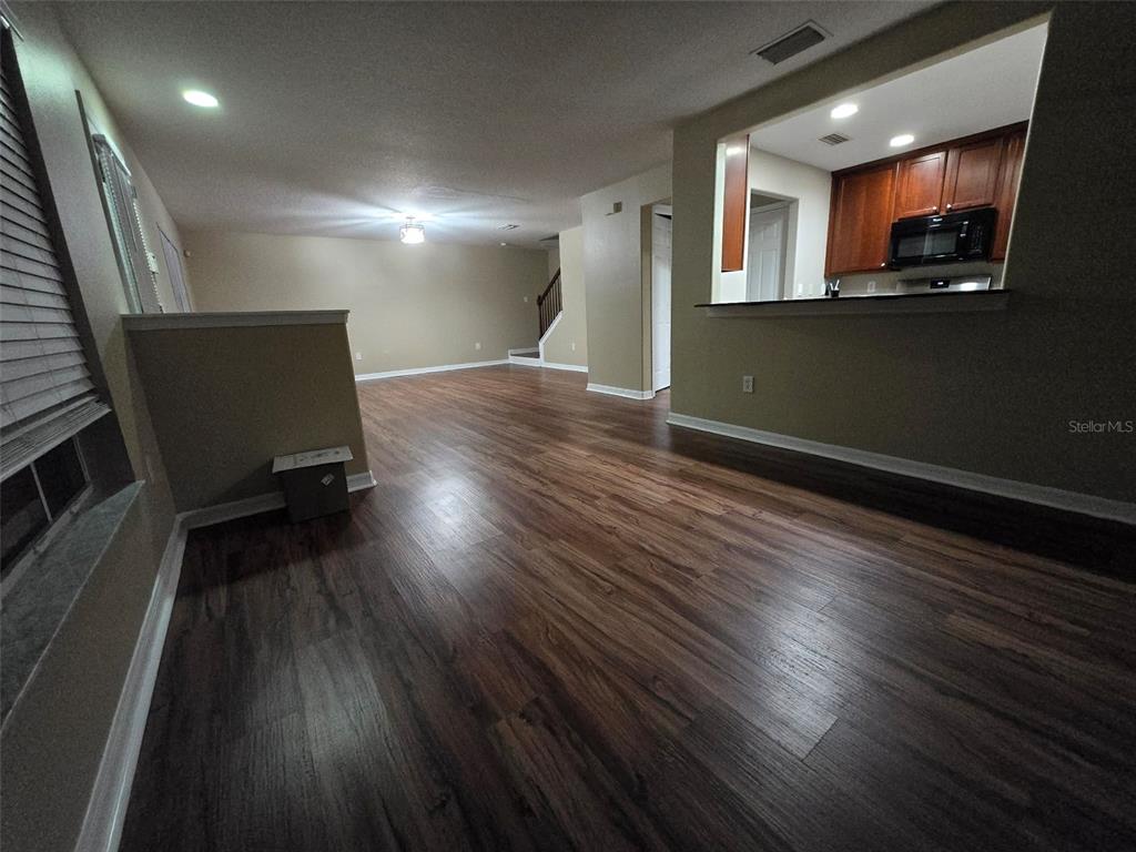 12905 Trade Port Place Riverview, FL 33579 - Photo 5 of 14 a view of a livingroom with wooden floor and a kitchen