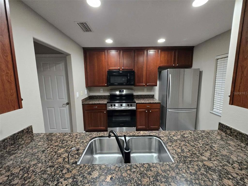 12905 Trade Port Place Riverview, FL 33579 - Photo 7 of 14 a kitchen with a refrigerator and a sink