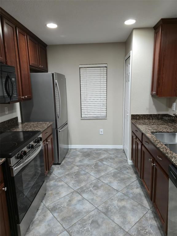 12905 Trade Port Place Riverview, FL 33579 - Photo 10 of 14 a kitchen with granite countertop a stove top oven and refrigerator