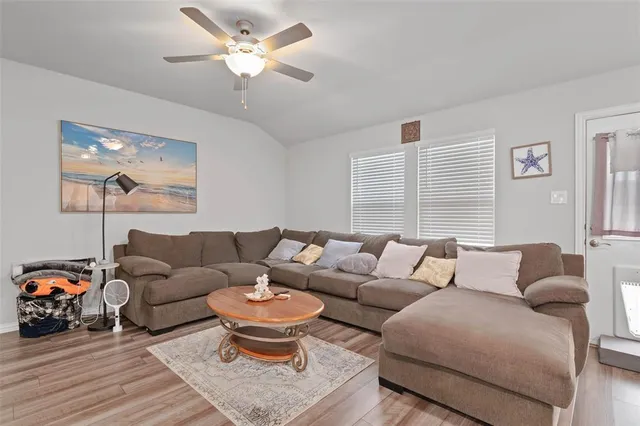 a living room with furniture a ceiling fan and a window