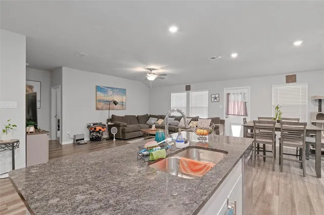 a large living room with stainless steel appliances granite countertop a couch a table and chairs