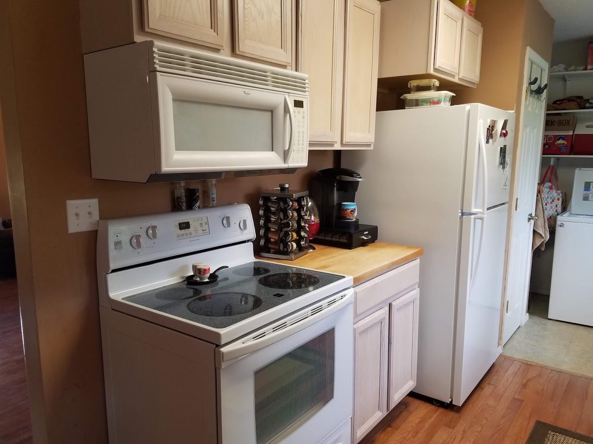 467 Ridge Road Lancing, TN 37770 - Photo 17 of 40 a kitchen with white cabinets and white appliances