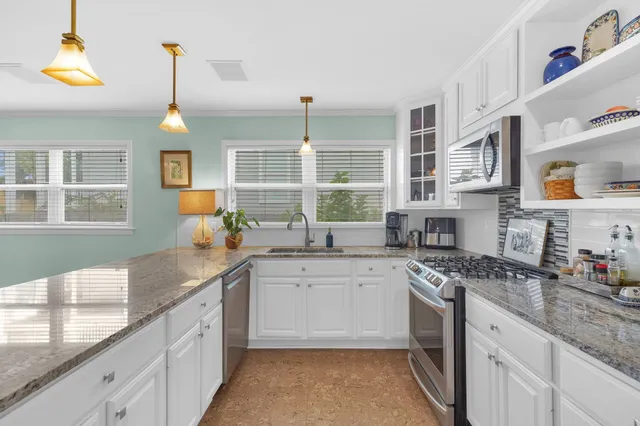 a kitchen with stainless steel appliances granite countertop a sink stove and cabinets