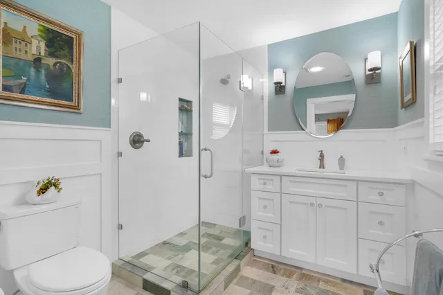a bathroom with a toilet a sink and glass door