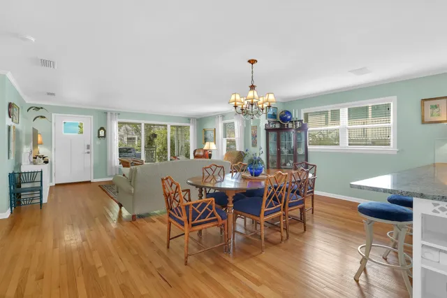 a view of a dining room with furniture a chandelier and wooden floor