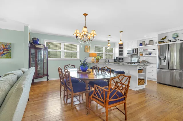 a view of a dining room with furniture a chandelier and wooden floor