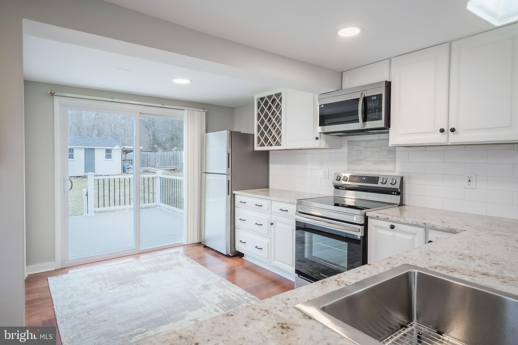 6946 Blantyre Road Warrenton, VA 20187 - Photo 1 of 24 a kitchen with stainless steel appliances granite countertop a stove a sink and a microwave