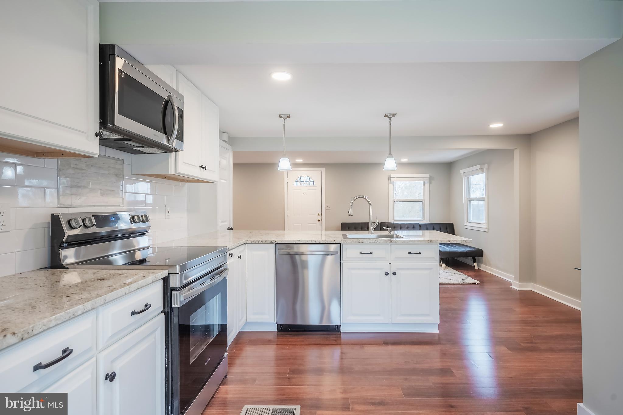 6946 Blantyre Road Warrenton, VA 20187 - Photo 8 of 24 a kitchen with a sink stove cabinets and wooden floor