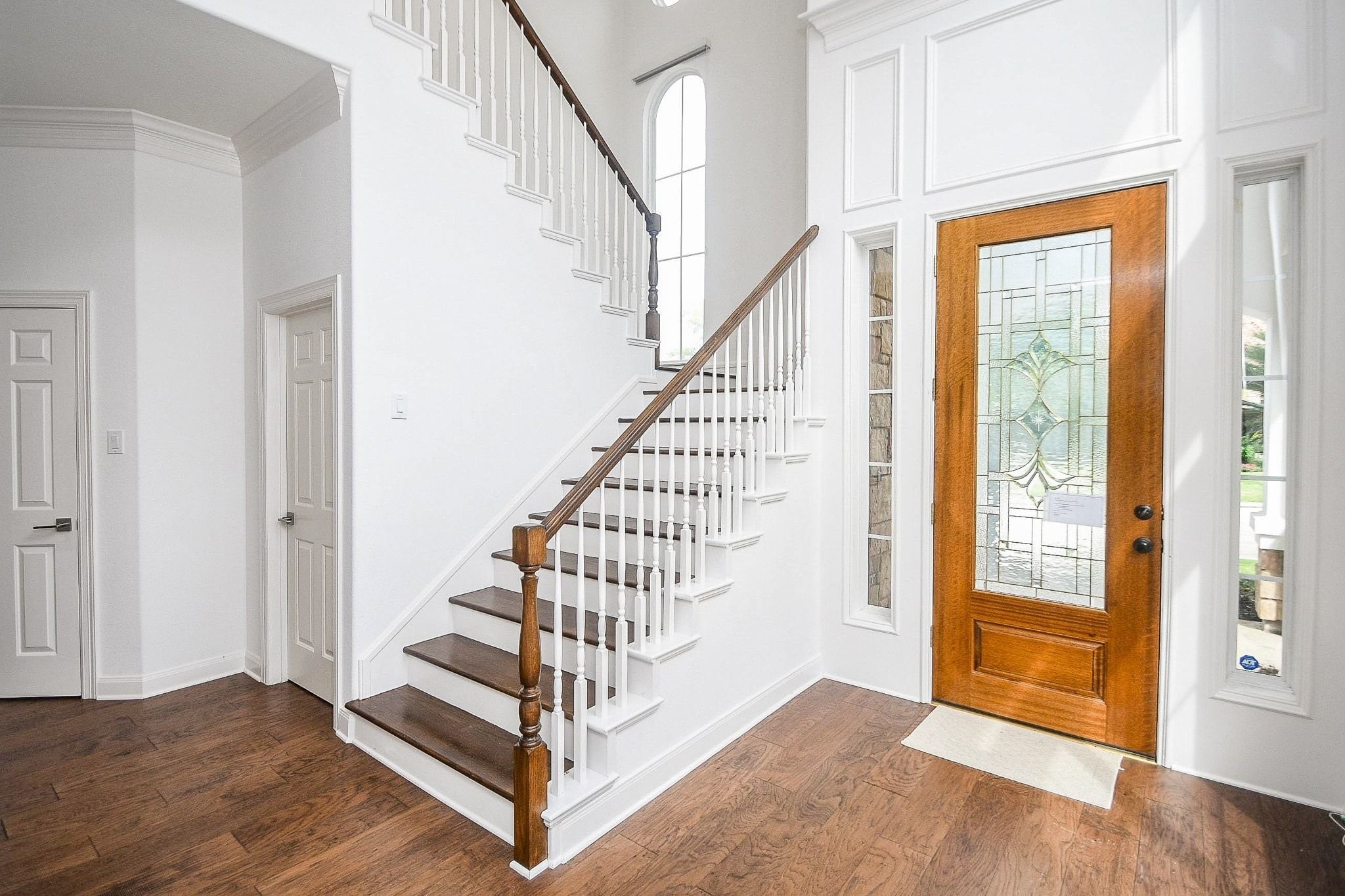 2826 Tudor Manor Houston, TX 77082 - Photo 3 of 37 This recently painted home features a stunning staircase, accented by a spacious landing area, a charming decorative window, and beautiful hardwood flooring throughout.