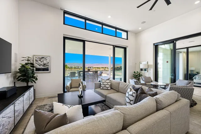 a kitchen with stainless steel appliances a sink a stove a refrigerator and chairs