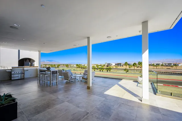 a living room with furniture a chandelier and a floor to ceiling window