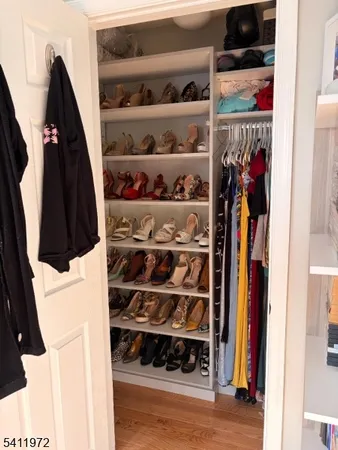 a view of walk in closet with clothes and shoes