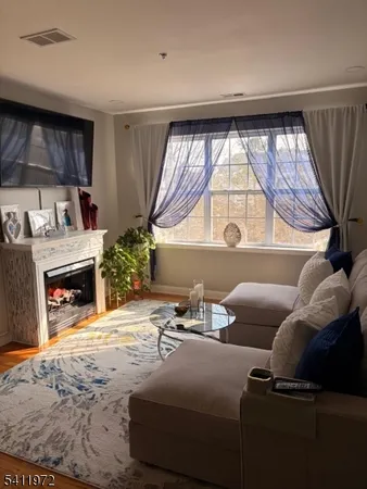 a living room with furniture a fireplace and a large window